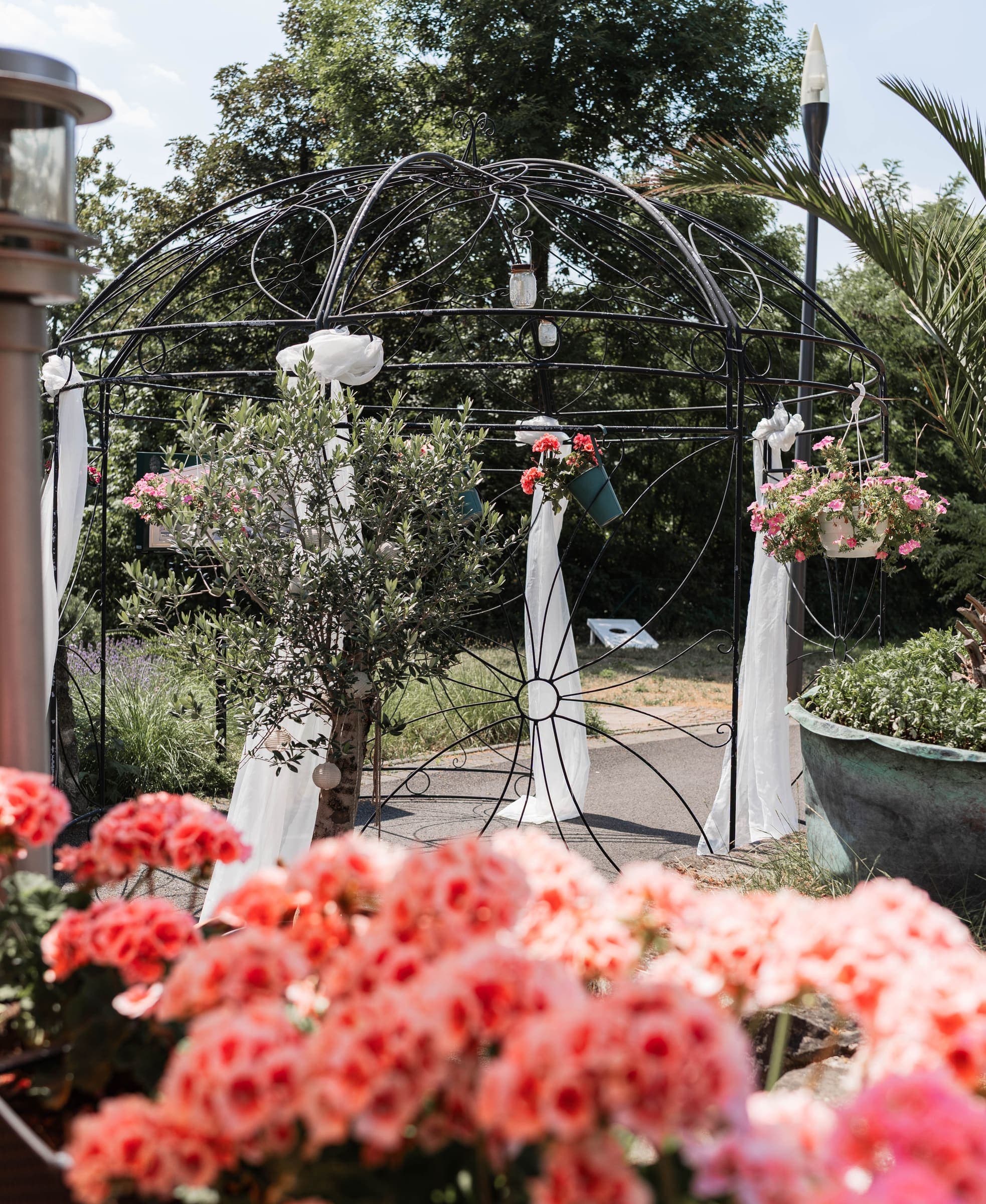 Pavillon mit weißer Hochzeits-Dekoration und blühenden Blumen im Garten der Villa Meßmer